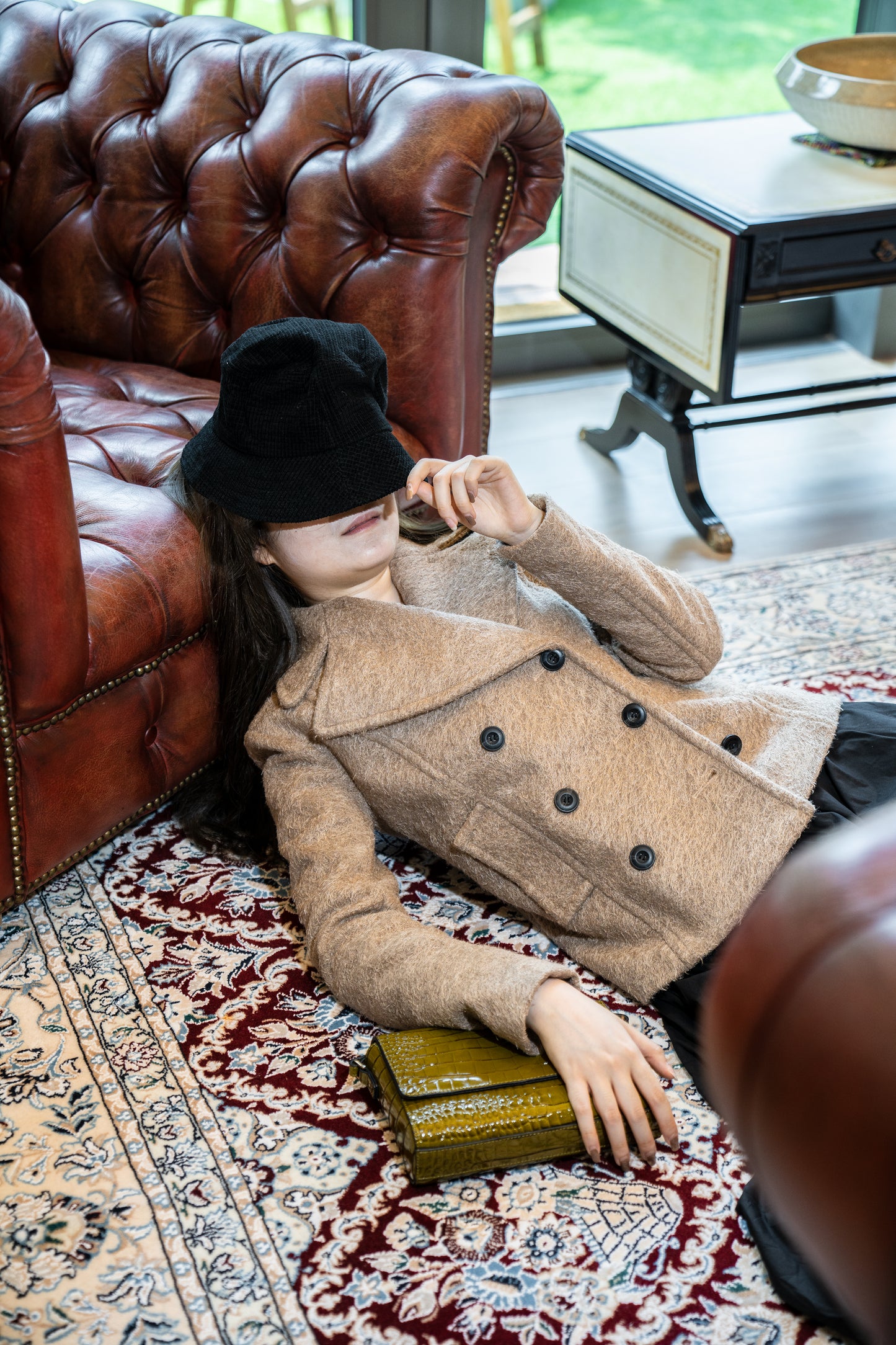 Our model was lying on the ground, while wearing the DOUBLE-BREASTED JACKET and holding the handbag MOSS under her right arm. The double-breasted jacket is designed to fit, featuring our rare find fabric in khaki.   The fabric is mid-to-heavy weighted, keeping you warm and cozy.  This perfect fit jacket sits right above the hip bone.  Best to keep a simple styling, style it with all black or tonal shades.